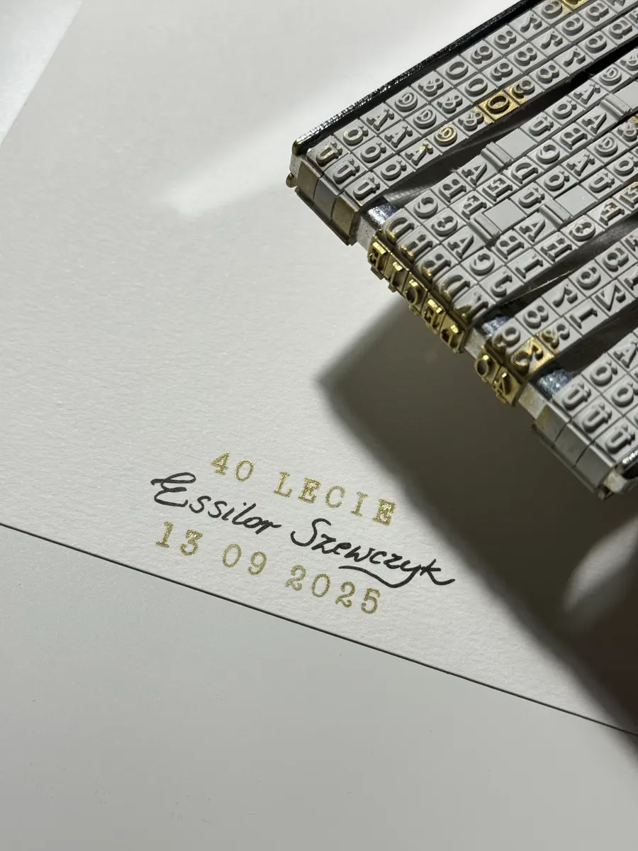 Złoty datownik odbijający nazwę i datę jubileuszu na papierze